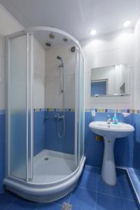 a blue bathroom with a shower and a sink at Umba Apartment N2 in Yerevan