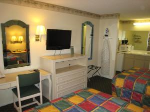 a room with a bedroom with a bed and a television at Town House Motel in Lancaster