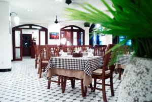 a dining room with a table and wooden chairs at Nam Bo Boutique Hotel in Can Tho