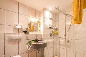 a bathroom with a sink and a shower at TOP-FeWo,Südterrasse,Wellness,Saunanutzung in Wertach