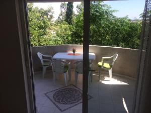 a patio with a table and chairs on a balcony at Apartments MiaMaja in Novalja