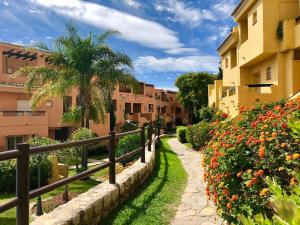 une passerelle à travers une ville avec des bâtiments et des fleurs dans l'établissement Apartamento Guadalmina - Golf & Playa - Marbella, à Marbella