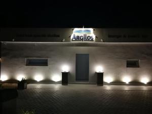 a building with a sign on the side of it with lights at Argilos in Sidari