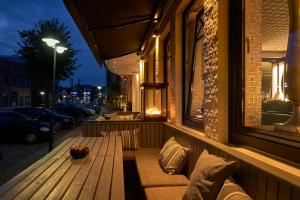 a wooden bench sitting on the side of a building at Thomas Hotel Spa & Lifestyle in Husum