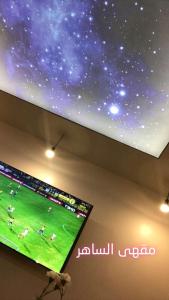 a flat screen tv hanging from a ceiling with a star ceiling at منازل الساهر للوحدات السكنية فرع 1 in Al Qunfudhah