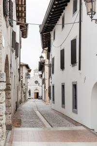 un callejón en un casco antiguo con edificios blancos en Al Campanile di San Daniele, en San Daniele del Friuli