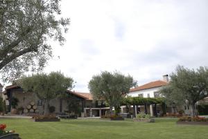 a large building with trees and a grass yard at Casa do Meio do Povo - Turismo de Habitação in Chaves