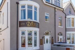 una tienda frente a un edificio con un cartel. en Beachcliffe Lodge Apartments en Blackpool