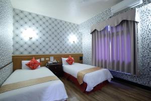 Habitación de hotel con 2 camas y ventana en Chiayi Crown Hotel, en Chiayi
