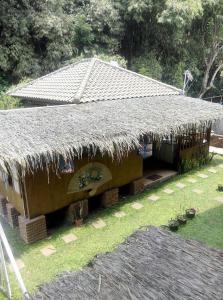 un edificio con tetto di paglia e piante all’interno di Villa Triniti Blok i-35 a Bandung