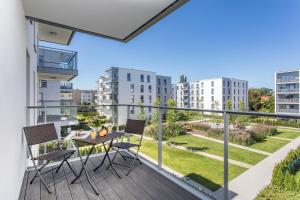 Un balcón de un apartamento con mesa y sillas en Seaside Beach 150m do Plaży - Praia Apartments - Polsat Plus Arena, en Gdansk