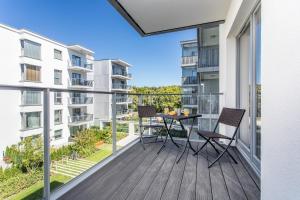 Cet appartement dispose d'un balcon avec une table et des chaises. dans l'établissement Seaside Beach 150m do Plaży - Parking - Praia Apartments - Polsat Ergo Arena Plus, à Gdańsk