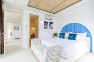 una camera con un grande letto e una sedia di Costa Village Bangsaray a Bang Sare