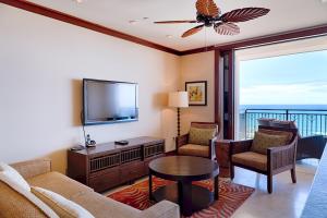 a living room with a couch and a tv and a table at TOP Floor Penthouse with Panoramic View - Ocean Tower at Ko Olina Beach Villas Resort in Kapolei