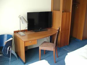a wooden desk with a television on top of it at Motel Monteur in Aschersleben