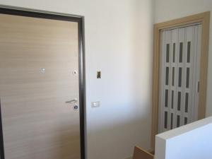 a wooden door in a room next to a hallway at Appartamento centralissimo Marina di Ragusa in Marina di Ragusa