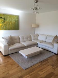 a living room with a white couch and a coffee table at Beautiful Kingston apartment in Kingston upon Thames +1 photo