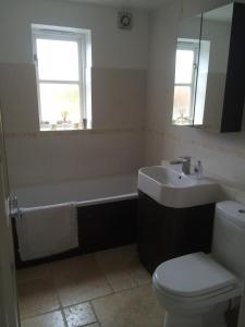 a bathroom with a tub and a sink and a toilet at Beautiful Kingston apartment in Kingston upon Thames