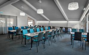 une salle de conférence avec des tables, des chaises et des chaises bleues dans l'établissement Torp Hotel, à Sandefjord