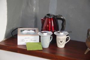 zwei Kaffeetassen und eine Schachtel auf einem Holzregal in der Unterkunft Camere Mazzini 49 in Sansepolcro