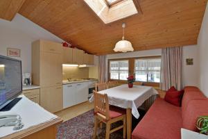 eine Küche und ein Wohnzimmer mit einem Tisch und einem Sofa in der Unterkunft Gästehaus Elfriede in Mayrhofen