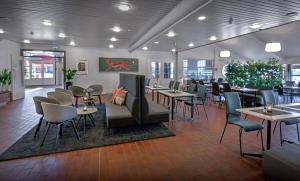 um restaurante com mesas e cadeiras num quarto em Torp Hotel em Sandefjord