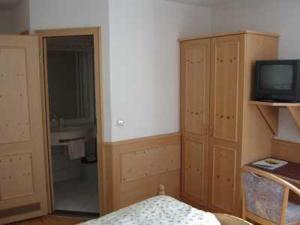 a room with a bed and a television and a bathroom at Hotel Gasthof Stern in Mindelheim
