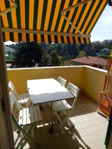 a table and chairs on a balcony with an umbrella at N148 - Numana, nuovo trilocale con terrazzo a 350 metri dal mare in Numana