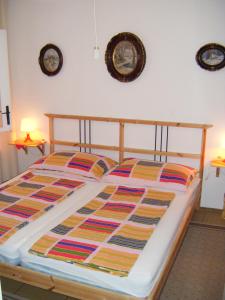 a bed in a bedroom with two pictures on the wall at Apartments Adria Blue in Jelsa