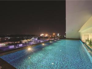 - une piscine sur le toit d'un bâtiment la nuit dans l'établissement Iconic Hotel, à Bukit Mertajam