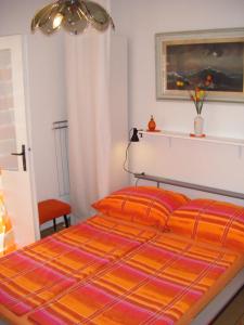 a bedroom with a bed with an orange comforter at Apartments Adria Blue in Jelsa