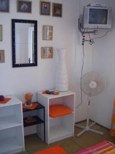 a room with a television and a table with a lamp at Apartments Adria Blue in Jelsa