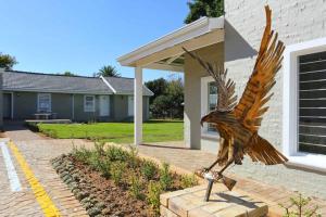 una estatua de un pájaro metálico frente a una casa en Eagle Cove, en Honeydew