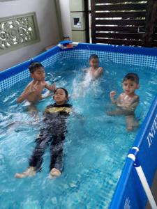een groep kinderen in een zwembad bij Damai Holiday Homestay in Melaka
