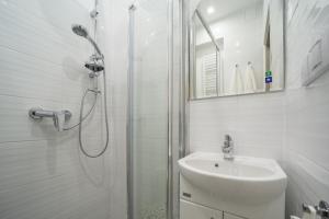 a bathroom with a shower, sink, and toilet at White Vision Apartment in Opole
