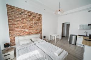 - une chambre avec un mur en briques et un lit dans l'établissement White Vision Apartment, à Carolinensiel