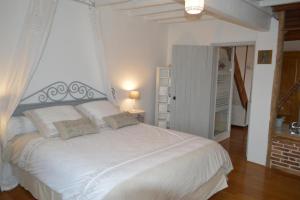 - une chambre avec un grand lit blanc dans l'établissement gîte du Clos Sébastien, à Beautheil