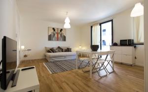 uma sala de estar branca com uma mesa e um sofá em Balaguer House em Alghero