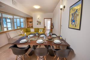 a dining room table and chairs in a living room at Zimmer Club in Kefar Weradim