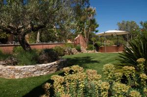 un jardín con un árbol y una pared de piedra en Bastide de l'Avelan en Grimaud