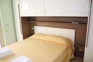 a bedroom with a bed with a wooden headboard at BB Aretè in Scilla