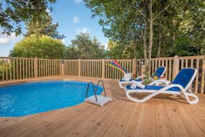 una terraza con 2 sillas y una piscina en Zimmer Club en Kefar Weradim