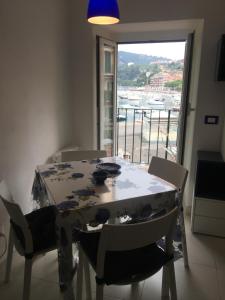 einen Esstisch mit Stühlen und ein großes Fenster in der Unterkunft Il mare di Cecy - Splendido Appartamento in Lerici