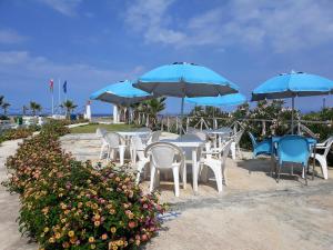 a group of tables and chairs with umbrellas on the beach at Yachting Club Mare in Patti