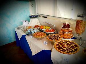 una mesa con pasteles y otros alimentos en ella en Yachting Club Mare en Patti