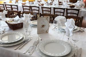 a table with plates and silverware on a white table cloth at Le Tre Rose in Bono