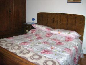a bed with pink and white sheets and pillows at Casa Dina in Terontola