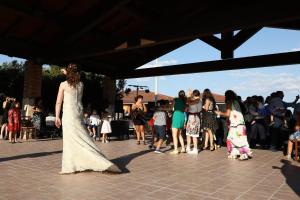 a woman in a white dress walking in front of a crowd at Le Tre Rose in Bono