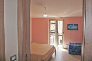 a bedroom with a bed and a tv on a wall at BB Aretè in Scilla