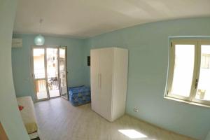 a room with a white refrigerator and a window at BB Aretè in Scilla